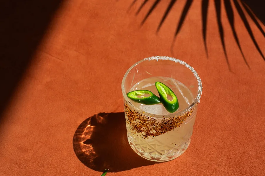 A chilled drink on a terracotta table under palm shadows at ASAI Cafe