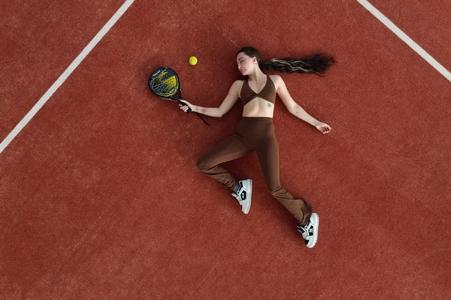 A player resting on the terracotta padel court at ASAI Village